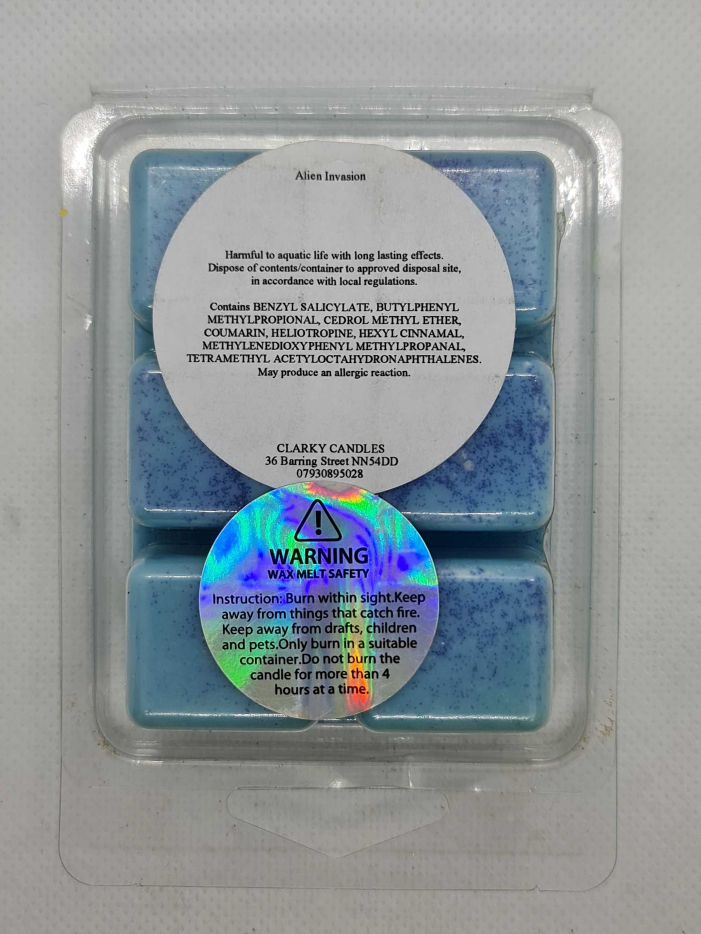Alien Invasion Wax Melt by Clarky Candles, blue wax cubes with safety and ingredient labels, cosmic and otherworldly fragrance.