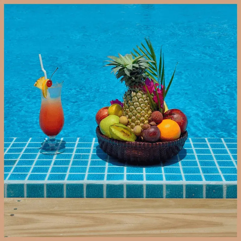 Tropical fruit basket and cocktail by poolside evoking Bora Bora scented soy candle tropical paradise escape