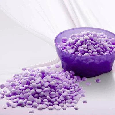 Purple Dreams Unstoppable Wax Melt beads spilling from a small bowl on a white surface