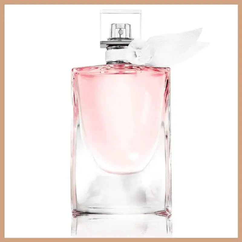 La Vie Est Belle scented soy wax candle with elegant feminine fragrance and pink liquid in clear glass bottle