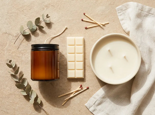 Flat lay of a 30cl jar candle, a wax melt snap bar, and a 3-wick bowl candle on a neutral background with eucalyptus and matches.