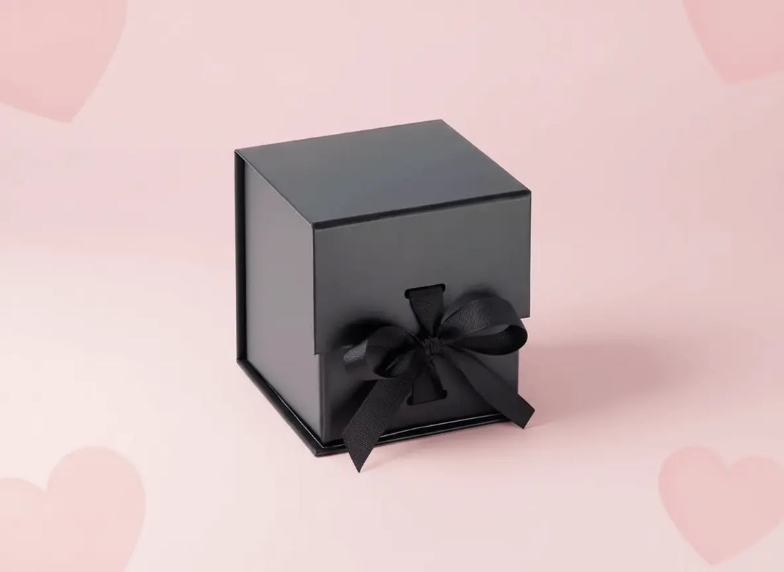 Luxury gift ideas 2026 UK in a sleek black gift box with a ribbon on a pastel pink background.