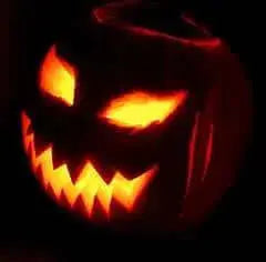 Halloween inspired carved pumpkin with glowing eyes and jagged mouth, perfect for Halloween decorations.