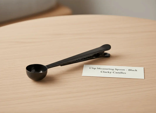 Clip Scooping Spoon - Black on a wooden table with a label from Clarky Candles