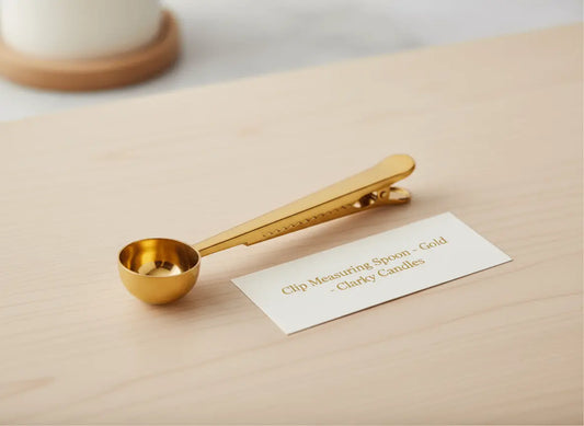 Clip Scooping Spoon Spoon - Gold on a wooden surface with a label from Clarky Candles.