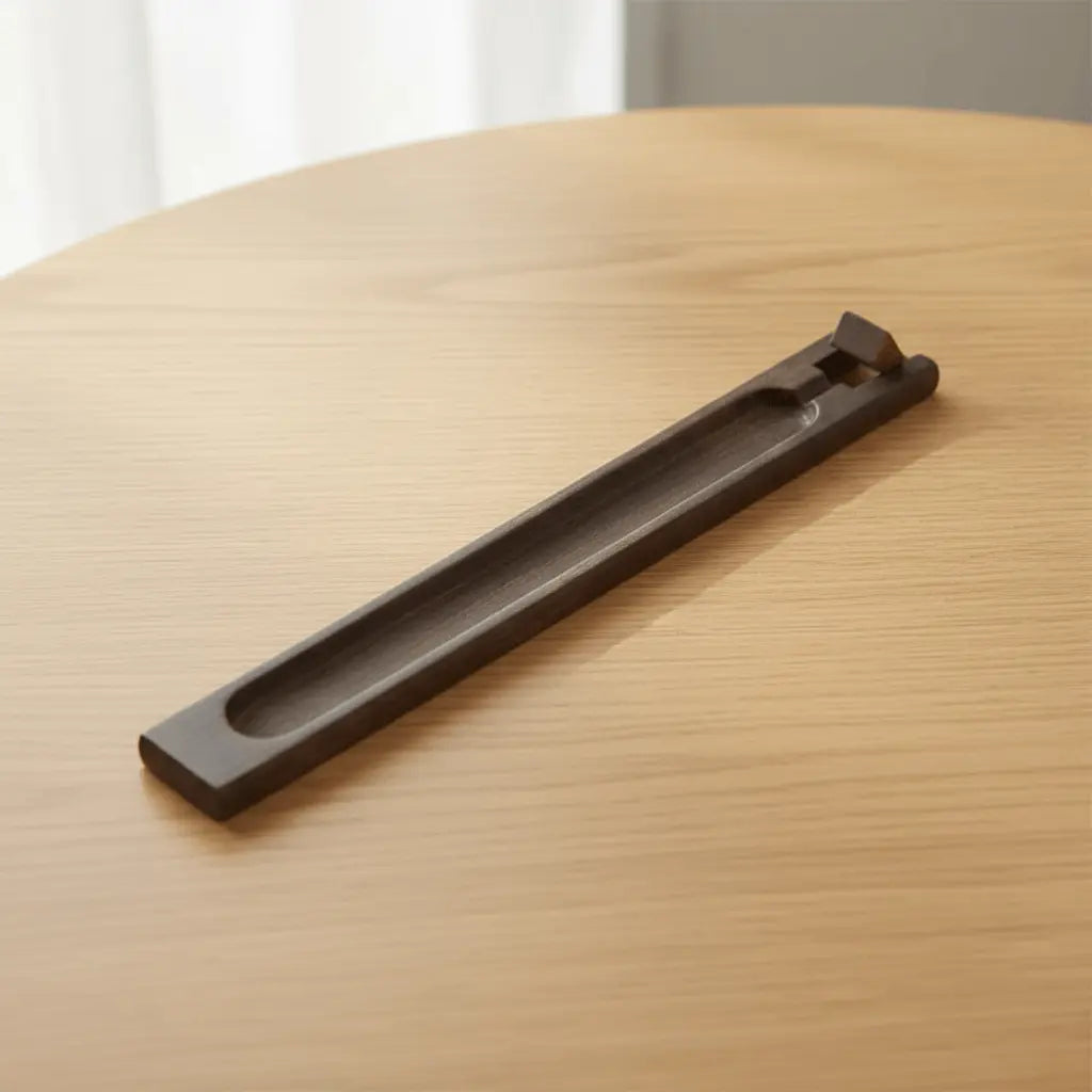 Incense Stick Wooden Holder on a wooden table, designed to catch ash and hold incense sticks at an angle.