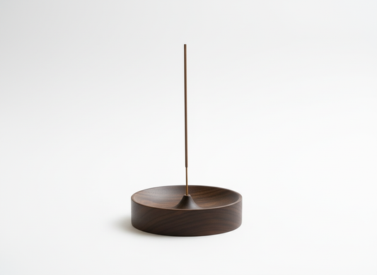 Solid wood incense stick holder with a minimal round ash catcher bowl and a single incense stick, photographed on a clean solid white background with soft studio lighting.